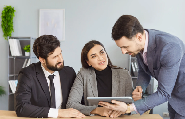 Lawyers discussing legal documents with a couple in an office, representing consultation for fatal accident claims and financial compensation.